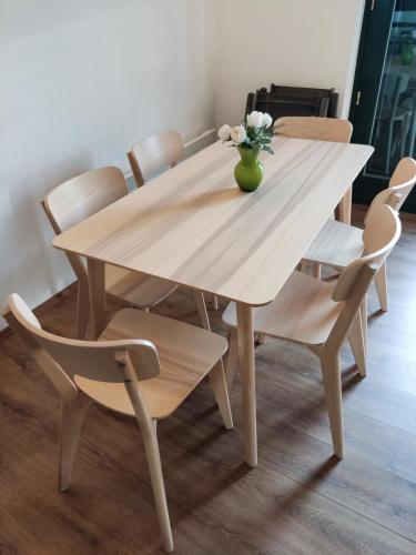 a wooden table with chairs and a vase of flowers on it at Peace & Beach House in Tihany, Sajkod in Tihany
