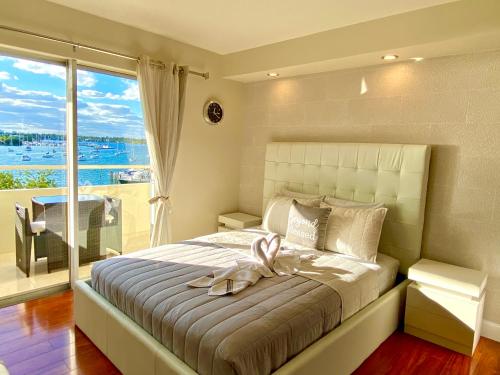 ein Schlafzimmer mit einem großen Bett und einem großen Fenster in der Unterkunft Modern waterfront apartment with free parking 5 mins drive to Miami Beach in Miami Beach