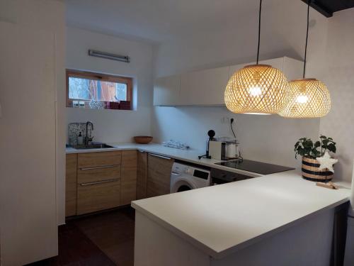 a kitchen with a white counter and a light fixture at Peace & Beach House in Tihany, Sajkod in Tihany