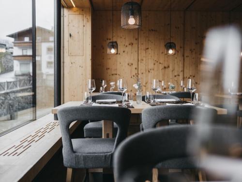 a dining room with a table and chairs and a window at VAYA Galtür Paznaun in Galtür