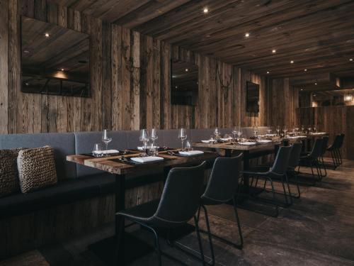 a row of tables in a room with wooden walls at VAYA Galtür Paznaun in Galtür