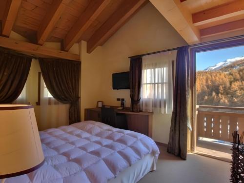a bedroom with a bed and a large window at Hotel Bait de Angial in Livigno