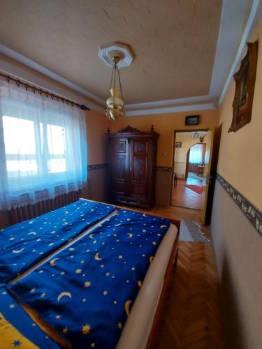 una camera da letto con un letto con un piumone blu di Fenyves Vendèghàz a Tapolca