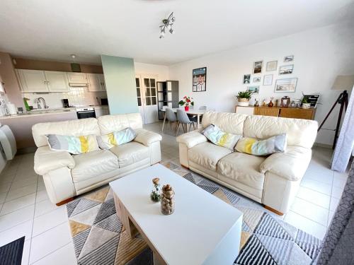 - un salon avec deux canapés blancs et une table dans l'établissement Villa Louise - Appartement Spacieux proche digue avec jardin, à Wimereux