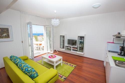 een woonkamer met een gele bank en een tafel bij 55 & 54 Stairs Apartments in Dubrovnik