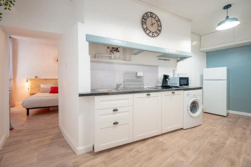 une cuisine avec des armoires blanches et une laveuse et une sécheuse dans l'établissement Charme urbain entre gare & port - Animaux acceptés, à Toulon