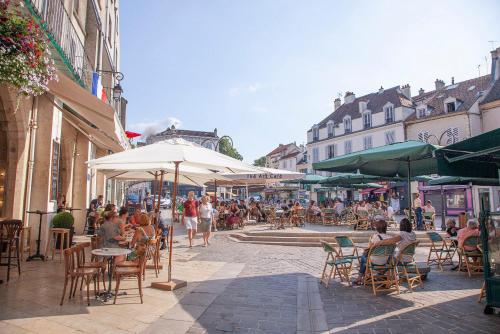 a group of people sitting at tables on a city street at Hyper centre ville - Bord de Marne in Lagny