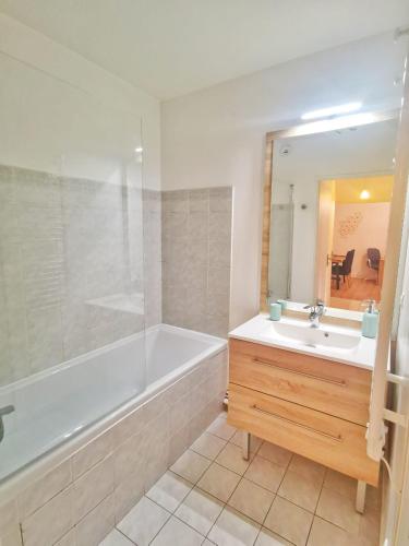 une salle de bain avec une baignoire, un lavabo et un miroir dans l'établissement Hyper centre ville - Bord de Marne, à Lagny-sur-Marne