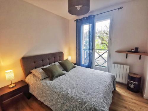 a bedroom with a bed and a large window at Hyper centre ville - Bord de Marne in Lagny