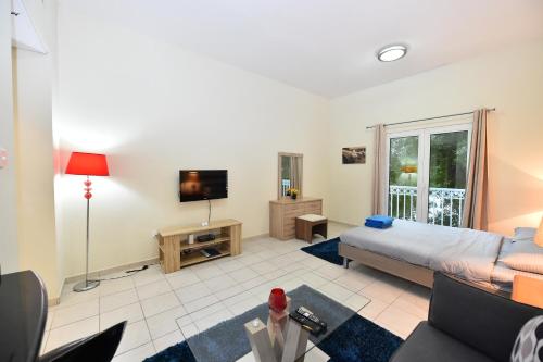 a living room with a bed and a tv at Luxury Escapes - Budget-Friendly Studio Near Metro - MED67 DG in Dubai