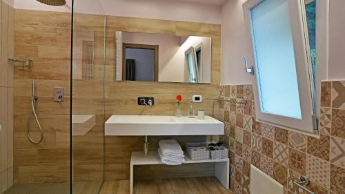 La salle de bains est pourvue d'un lavabo et d'une douche. dans l'établissement VILLA PROVENZA 12&4, Emma Villas, à Cefalù