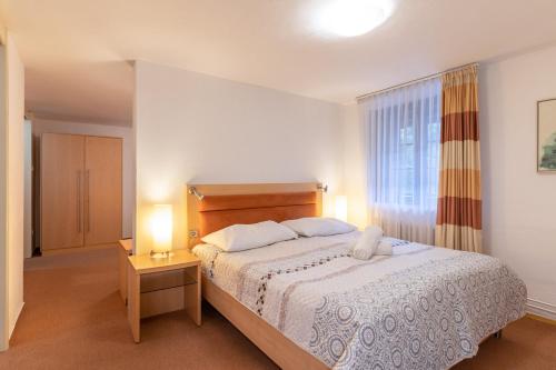 a bedroom with a large bed and a window at Penzion Sykovec in Tři Studně