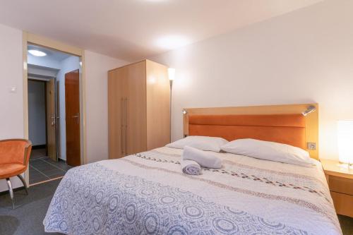 a bedroom with a large bed with two pillows on it at Penzion Sykovec in Tři Studně