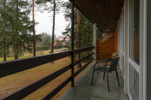 a porch of a house with a chair on it at Penzion Sykovec in Tři Studně