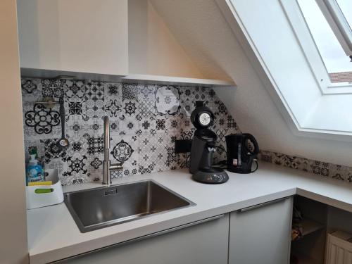 a kitchen with a sink and black and white wallpaper at Maisonette-Wohnung mit Balkon in Radolfzell am Bodensee