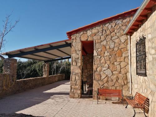 a stone building with a bench in front of it at EL MIRADOR DEL CORNEJA in Mesegar de Corneja