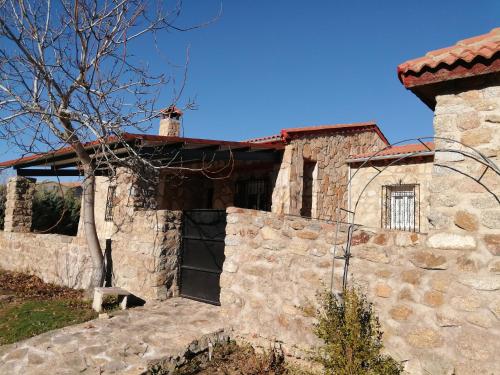 een oud stenen huis met een stenen muur bij EL MIRADOR DEL CORNEJA in Mesegar de Corneja