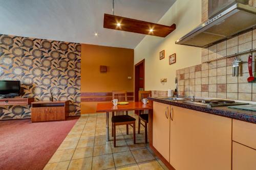 a kitchen with a wooden table in a room at Apartmánový dom Slniečko in Žiar
