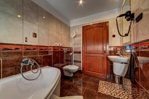 a bathroom with a tub and a sink and a toilet at Apartmánový dom Slniečko in Žiar