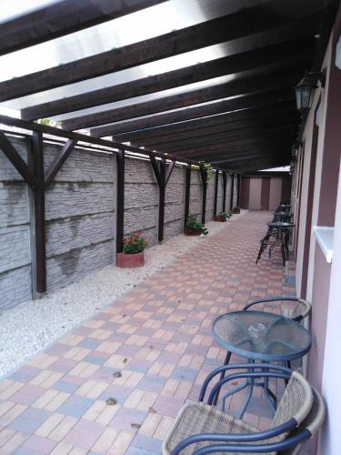 a patio with a table and chairs on a brick floor at Boglárka Vendégház in Mosonmagyaróvár