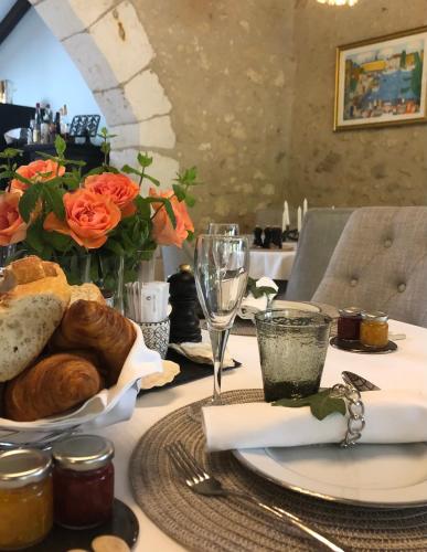 un tavolo con un piatto di pane e un bicchiere di vino di La Libertie a Campsegret