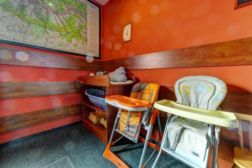 a childs room with orange walls and two chairs at Apartmánový dom Slniečko in Žiar