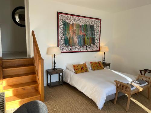 une chambre avec un lit et un tableau au mur dans l'établissement Monpazier Gite, à Monpazier