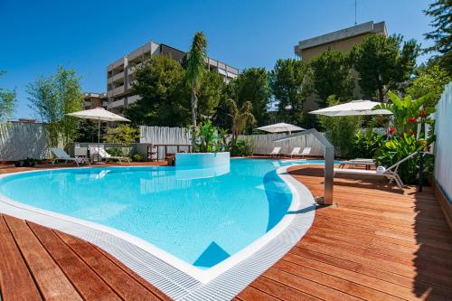 a swimming pool with a wooden deck and a building at Hi Hotel Bari in Bari