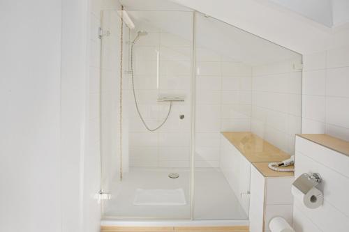a white bathroom with a shower with a glass door at Gästehaus Prinzregent Luitpold in Bad Steben