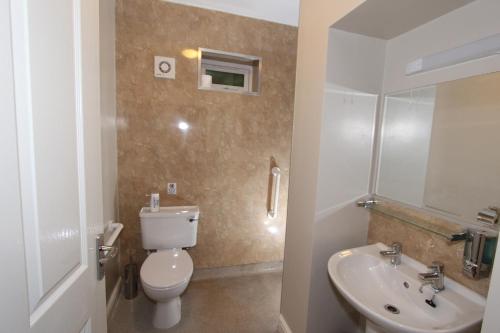 a bathroom with a toilet and a sink at Fern Howe Guest House in Keswick