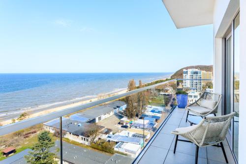 a balcony with two chairs and a view of the beach at Balticus Apartamenty Deluxe Promenada Gwiazd 14 in Międzyzdroje