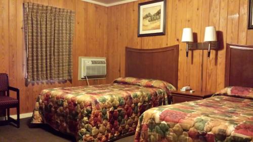 a hotel room with two beds and a tv at Texas Inn Motel in Marshall