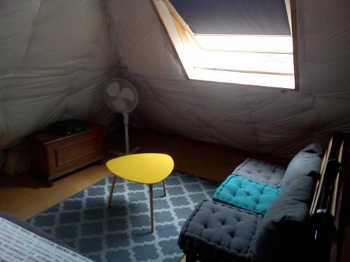 une chambre avec un canapé et une chaise dans une tente dans l'établissement la maison du bonheur chez Yann HUMBLET, à Moulis