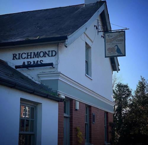 un edificio con una señal para un ejército de arapaho de Rutherford en The Richmond Arms Rooms en Funtington