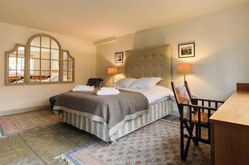 Habitación de hotel con cama y espejo en The White Swan Inn en Pickering