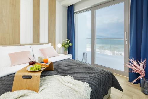 a bedroom with a bed with a tray of fruit on it at Balticus Apartamenty Deluxe Promenada Gwiazd 14 in Międzyzdroje