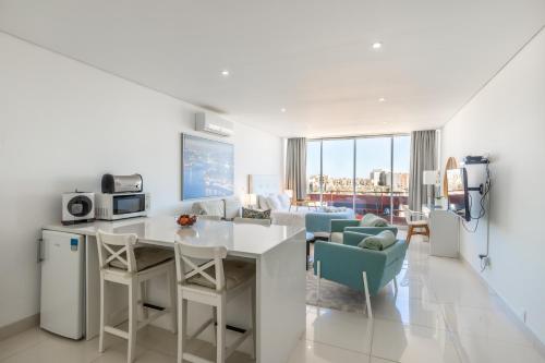 a kitchen and living room with a table and chairs at Estúdios Marina in Vilamoura