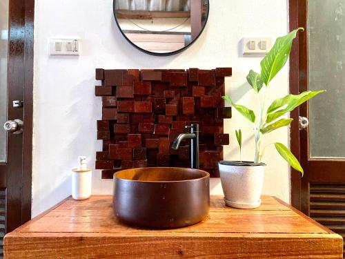 a copper sink on a wooden table with a plant at BOHO Hostel in Ko Lanta