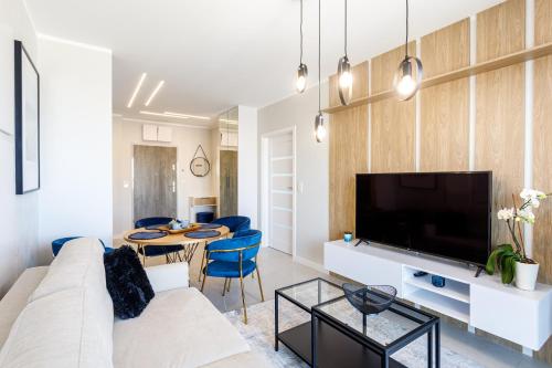 a living room with a couch and a tv at Balticus Apartamenty Deluxe Promenada Gwiazd 14 in Międzyzdroje
