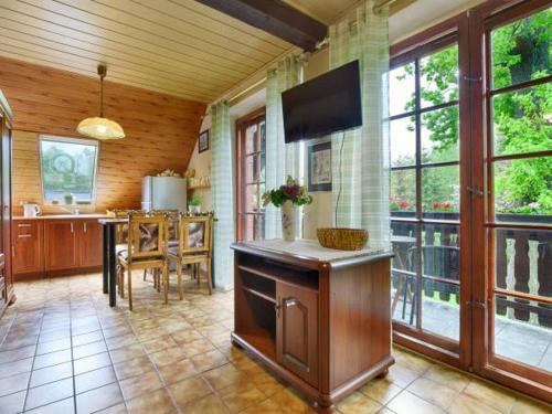 a large kitchen with a table and a tv at Apartamenty i pokoje Domino Parking w cenie ! in Karpacz