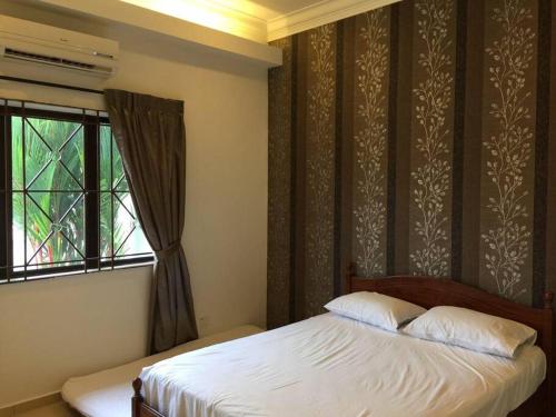 a bedroom with a bed and a window at MELAKA BEACH VILLA ( B TYPE ) in Melaka