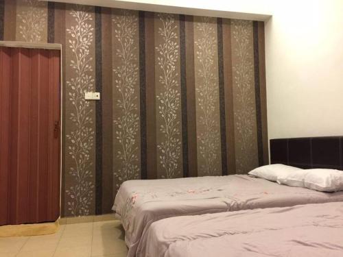 a bedroom with two beds and a wall with stripes at MELAKA BEACH VILLA ( B TYPE ) in Melaka