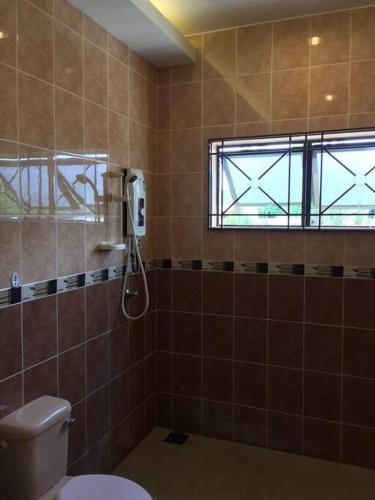 a bathroom with a shower and a toilet and a window at MELAKA BEACH VILLA ( B TYPE ) in Melaka