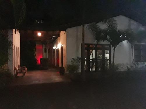 a building at night with a palm tree in front of it at Villa DeLorenta in Anuradhapura