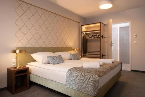 a bedroom with a large bed and a mirror at Xerion Hotel in Kraków