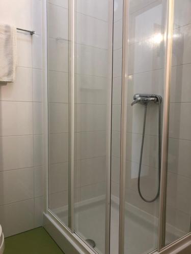 une douche avec une porte en verre dans une salle de bain dans l'établissement Apartamento Mar com Parking, à Nazaré