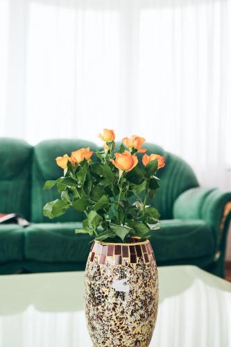 a vase with orange flowers sitting on a table at Hotel EZIO in Chişinău