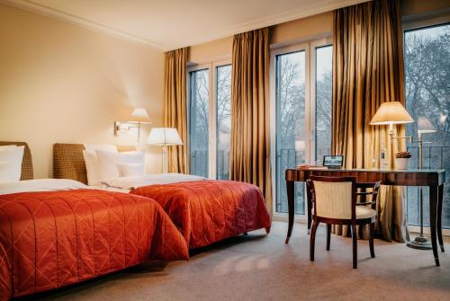 a hotel room with two beds and a desk at Parkhotel Bremen – ein Mitglied der Hommage Luxury Hotels Collection in Bremen