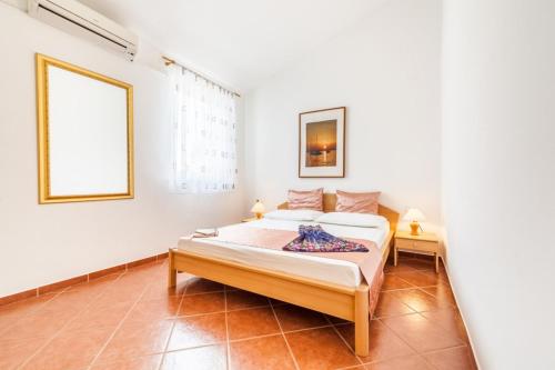 a white bedroom with a bed and a window at Apartment in Kustici with sea view, balcony, air conditioning, WiFi 3589-4 in Kustići