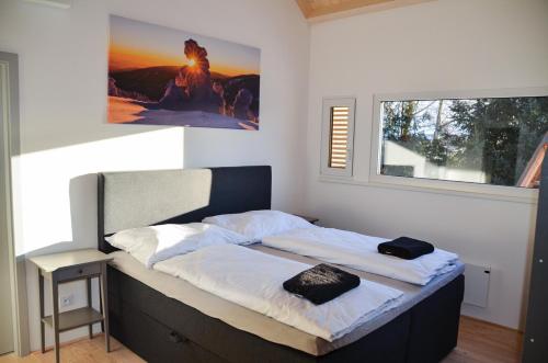 a bed in a bedroom with a picture on the wall at Slonovy CHaty in Dolní Morava